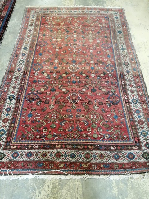 An antique Persian red ground rug, 220 x 142cm